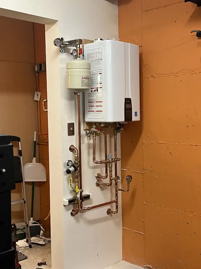 Plumbing technician inspecting water heater connections in Mount Morris